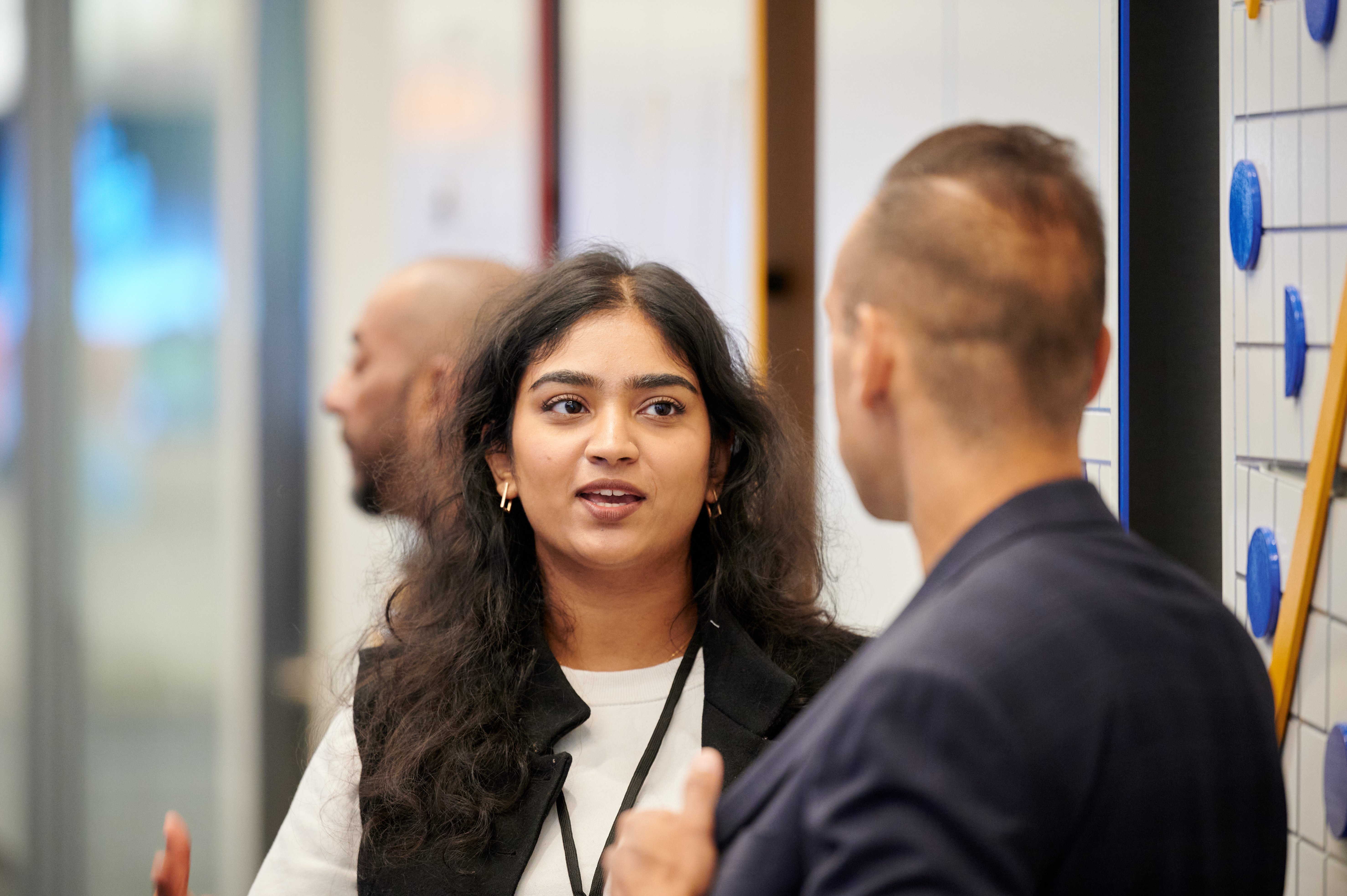 Young woman talking to participant at an event