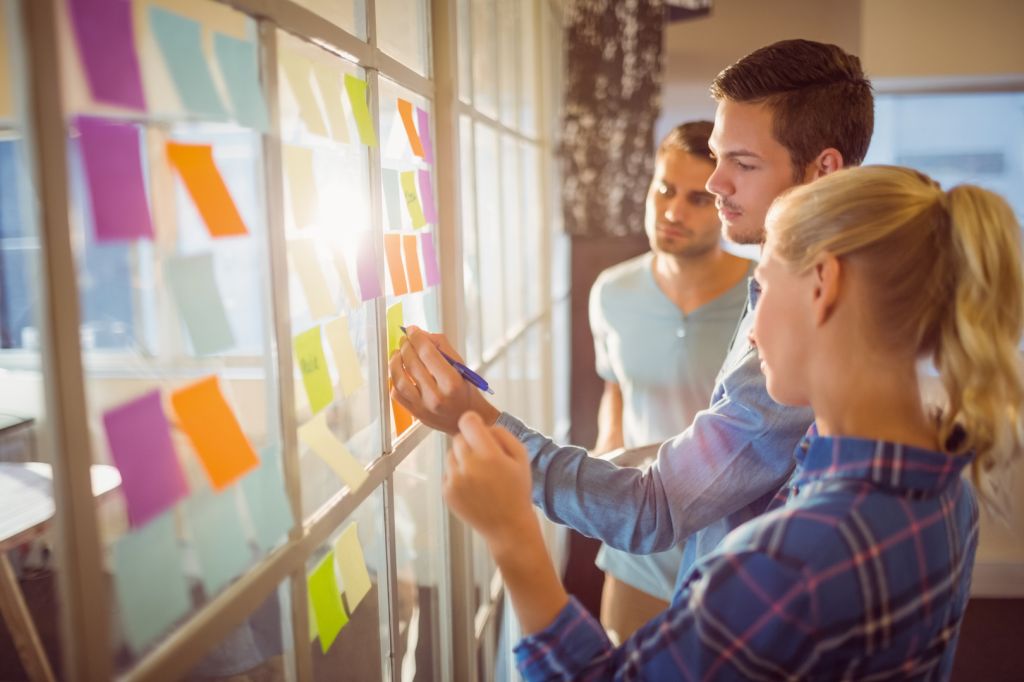 A group of office colleagues working together on a board.