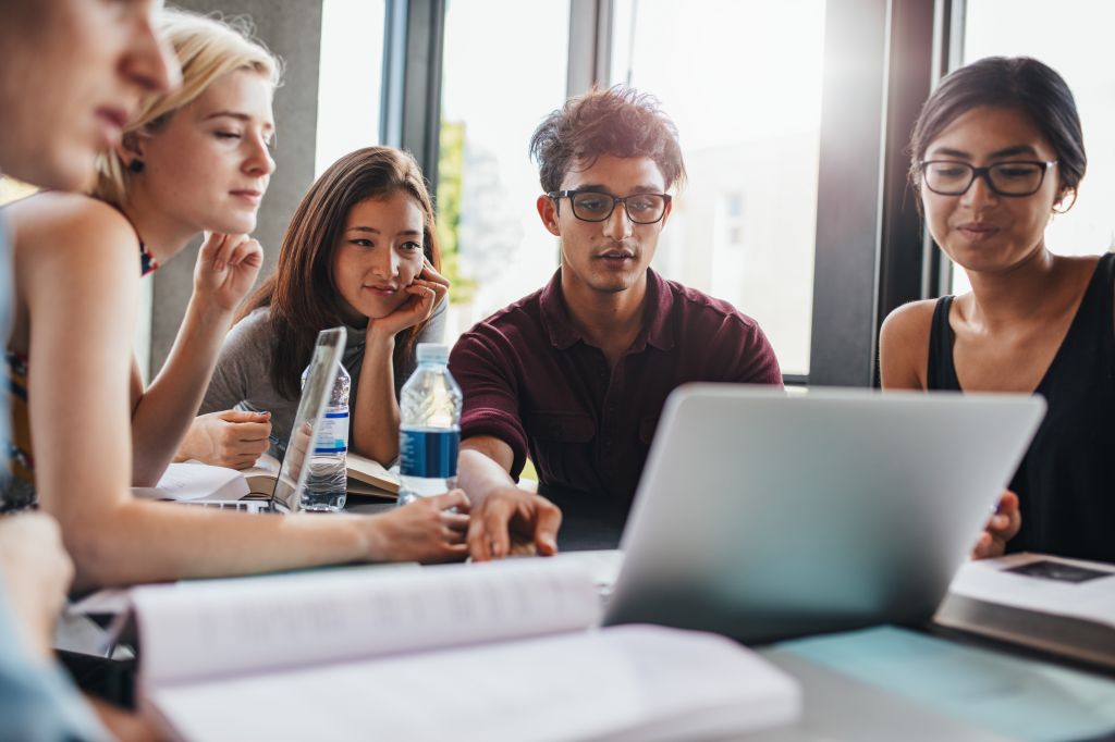 A group of college students looking at laptop.